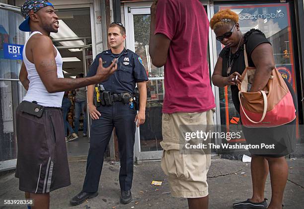 Baltimore Police Officer Yezzi talks with local B.J. Johnson and others on north Pennsylvania Avenue, the area where a riot broke out when Freddie...