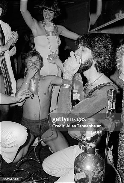 Clubgoers inhale nitrous oxide on the dance floor during the first annual Halloween party at Studio 54, New York, New York, October 31, 1977. The...