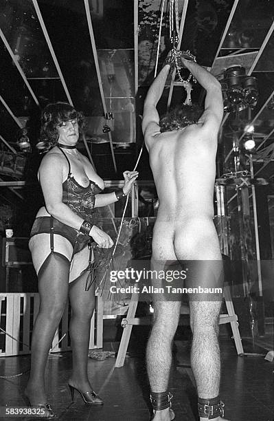 An unidentified dominatrix whips man during an S&M show at the Plato's Retreat swinger's club , New York, New York, July 14, 1980.
