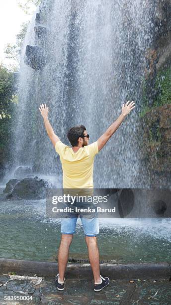 spanish young man happy smiling at cascade in nice, france - cascade france stockfoto's en -beelden