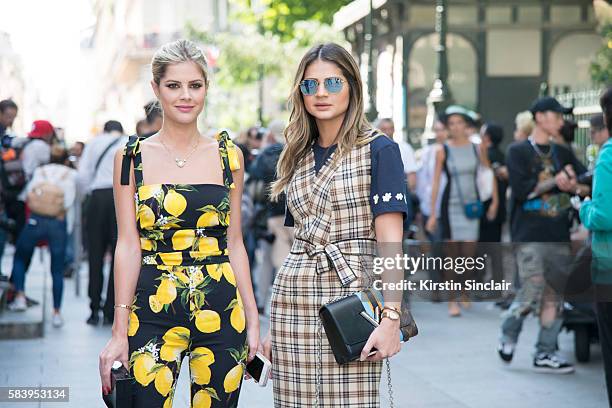 Fashion blogger Lala Rudge wears a Dolce & Gabbana jumpsuit, Chanel clutch bag with Fashion blogger Thassia Naves who wears a La Gaconne dress,...