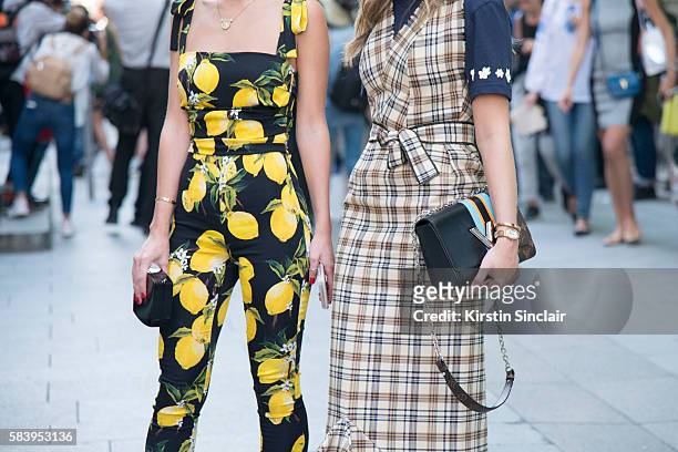 Fashion blogger Lala Rudge wears a Dolce & Gabbana jumpsuit, Chanel clutch bag with Fashion blogger Thassia Naves who wears a La Gaconne dress,...