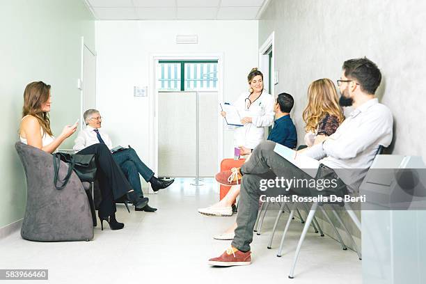 waiting room, mature female doctor talking to a patient - doctor with male patient reading notes stock pictures, royalty-free photos & images