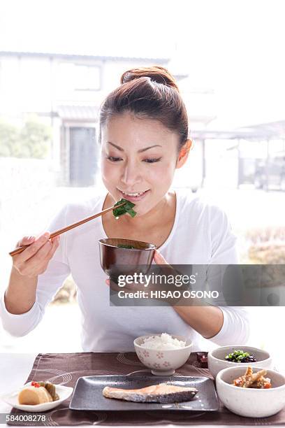 young woman eating japanese cuisine - misosuppe stock-fotos und bilder