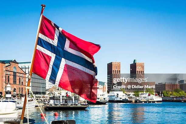 norway flag in front of oslo city hall and marina - oslo city hall stock-fotos und bilder