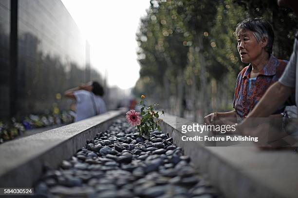 People visit the long marble wall inscribed with names of the 1976 earthquake victims hours before the 40th anniversary of the deadly earthquake...