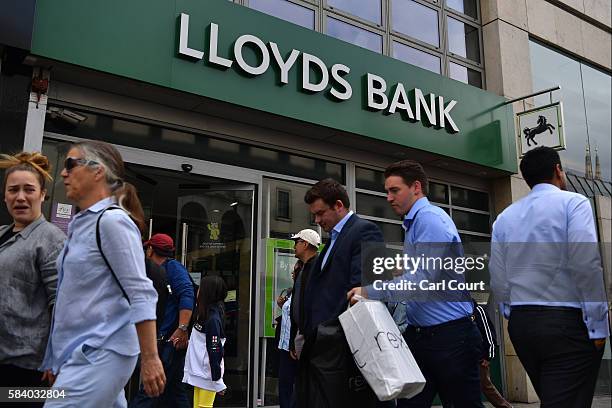 People walk past a branch of Lloyds Bank on July 28, 2016 in London, England. The part state-owned banking group today announced it will cut 3,000...