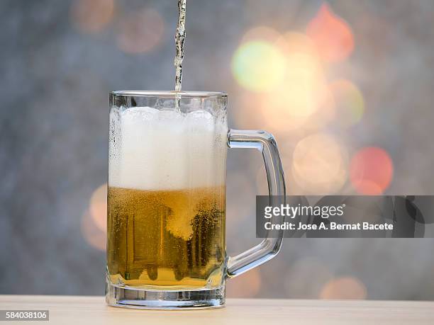 to fill a pitcher of crystal of beer with natural light - stein stock pictures, royalty-free photos & images