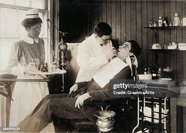 Photograph of a patient in a dentist's chair having dental work , 1917. Silver print.