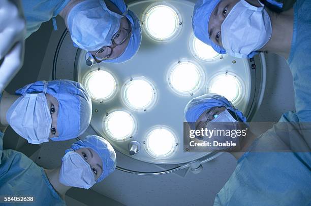 five surgeons from operating table - operationstisch stock-fotos und bilder