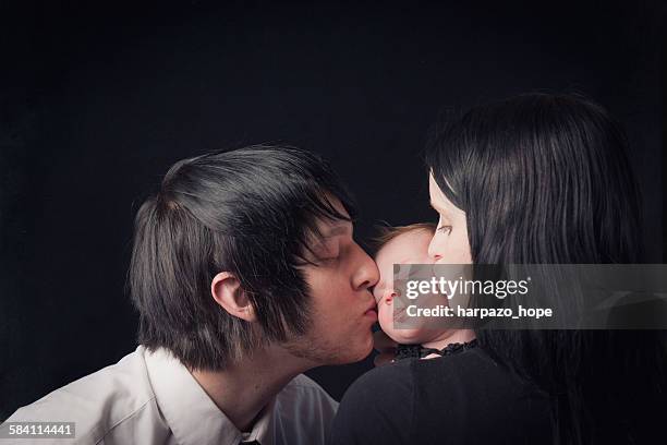 parents kissing their newborn's cheeks - emo stock pictures, royalty-free photos & images