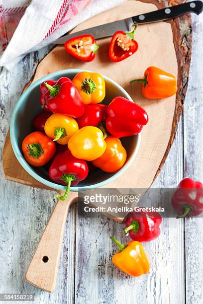 mini bell peppers in bowl - oranje paprika stockfoto's en -beelden