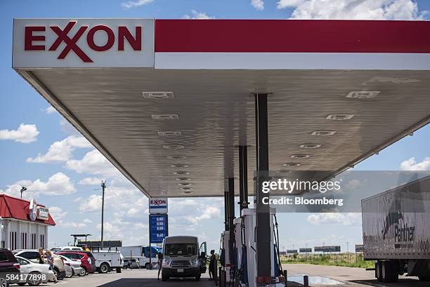 Customer puts fuel in her vehicle at an Exxon station outside Aurora, New Mexico, U.S., on Tuesday, July 26, 2016. Exxon Mobil Corp. Is scheduled to...