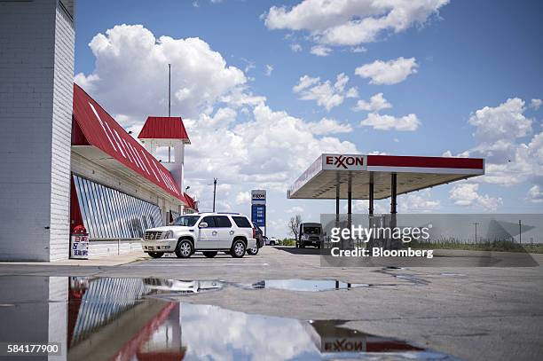 Exxon signage is reflected in a puddle as customers put fuel in their vehicles at a roadside Exxon gas station outside Aurora, New Mexico, U.S., on...