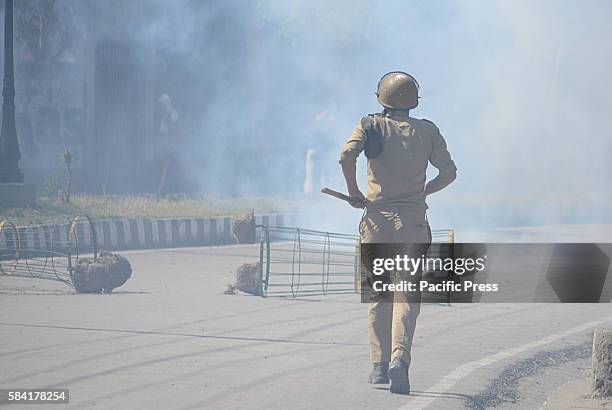 An Indian policeman chasing away Kashmiri muslim protesters. Protesters took out a peaceful march against the killing of most wanted Hizbul...