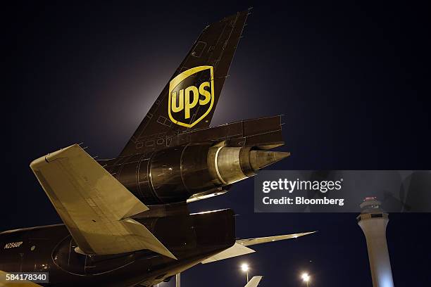 United Parcel Service Inc. Signage is displayed on the tail section of a McDonnell Douglas Corp. MD-11-F cargo jet on the tarmac at the UPS Worldport...