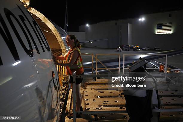 Worker stands on a hydraulic lift after unloading a cargo jet during the night package sort at the United Parcel Service Inc. Worldport facility in...