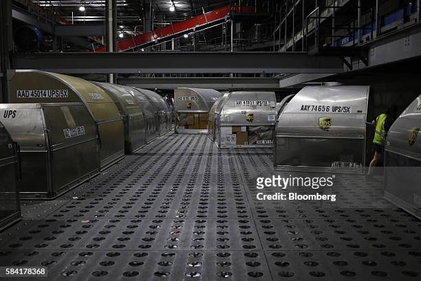 Package containers sit before being unloaded during the night package sort at the United Parcel Service Inc. Worldport facility in Louisville,...