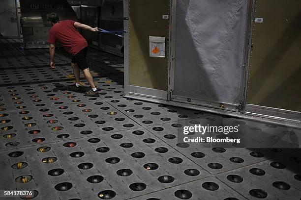 Worker pulls a package container to be unloaded during the night package sort at the United Parcel Service Inc. Worldport facility in Louisville,...