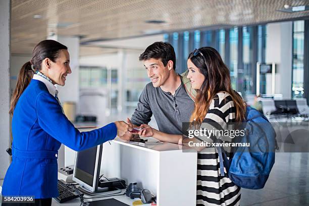 junges paar steigt am flughafen ins flugzeug - flughafen check-in stock-fotos und bilder