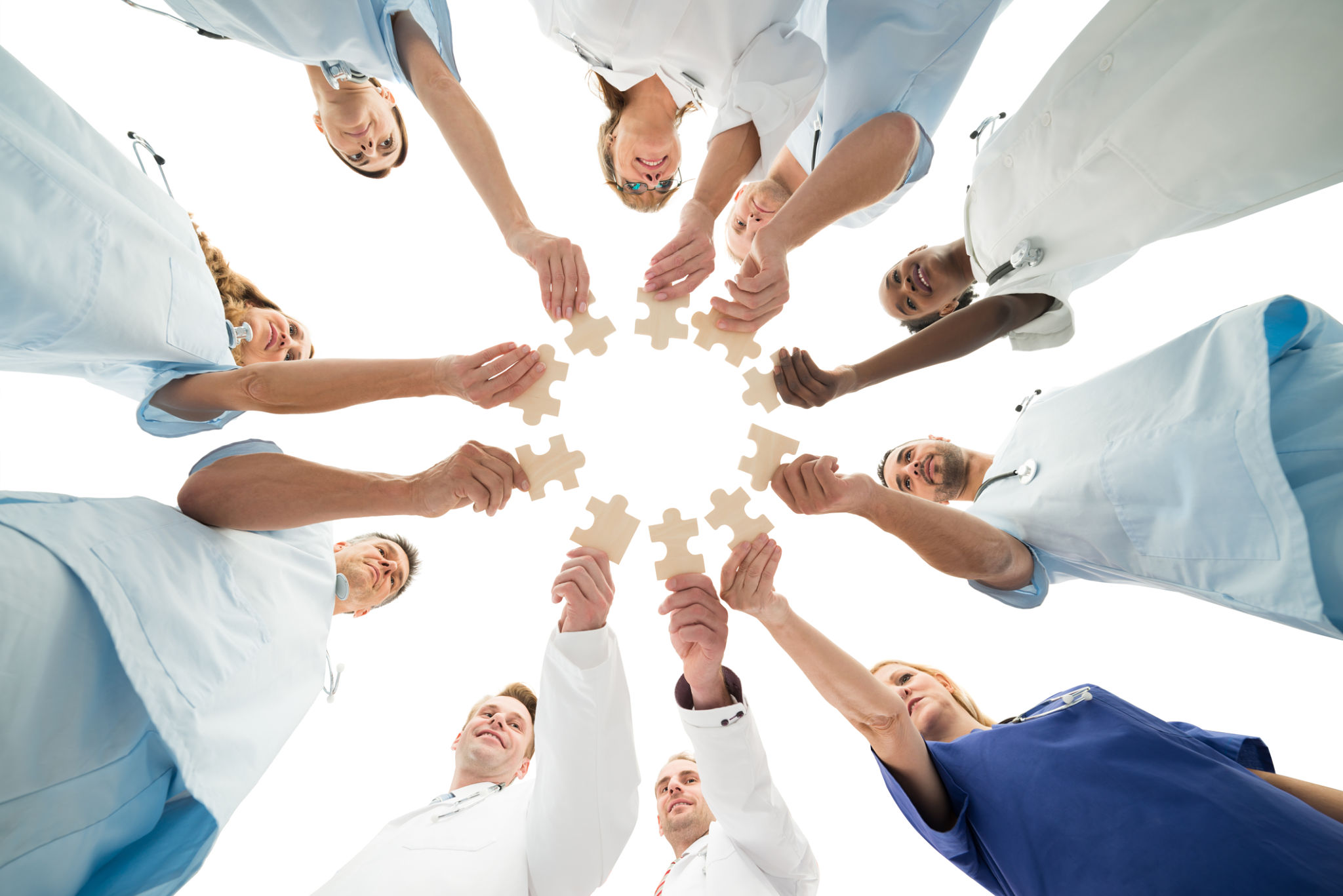 Medical Team Joining Jigsaw Pieces In Huddle Medical Team Joining Jigsaw Pieces In Huddle