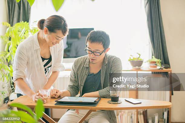 pareja de adultos medios mirando una tableta digital - pareja de mediana edad fotografías e imágenes de stock