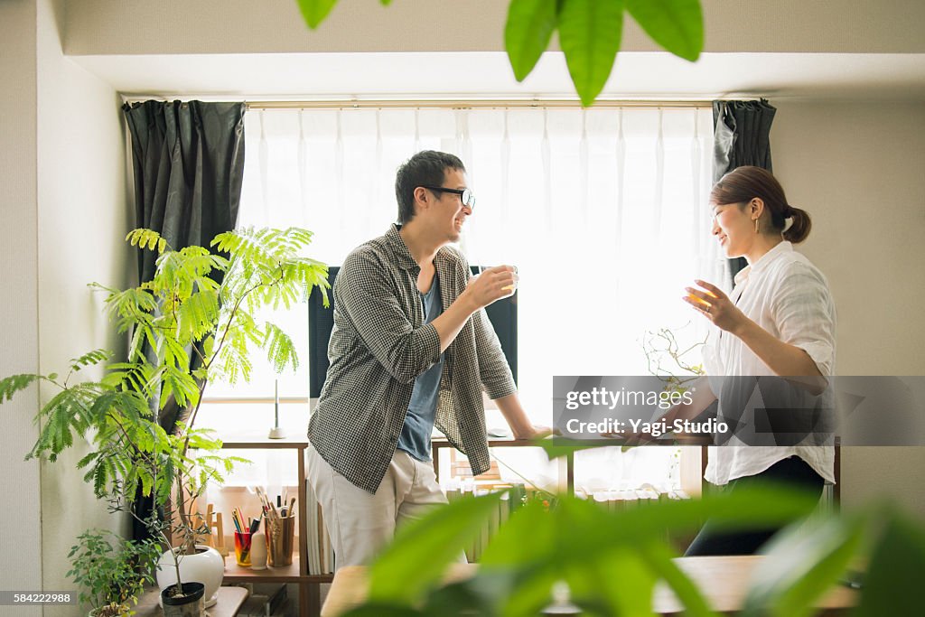 Mid adult couple drinking beer at home