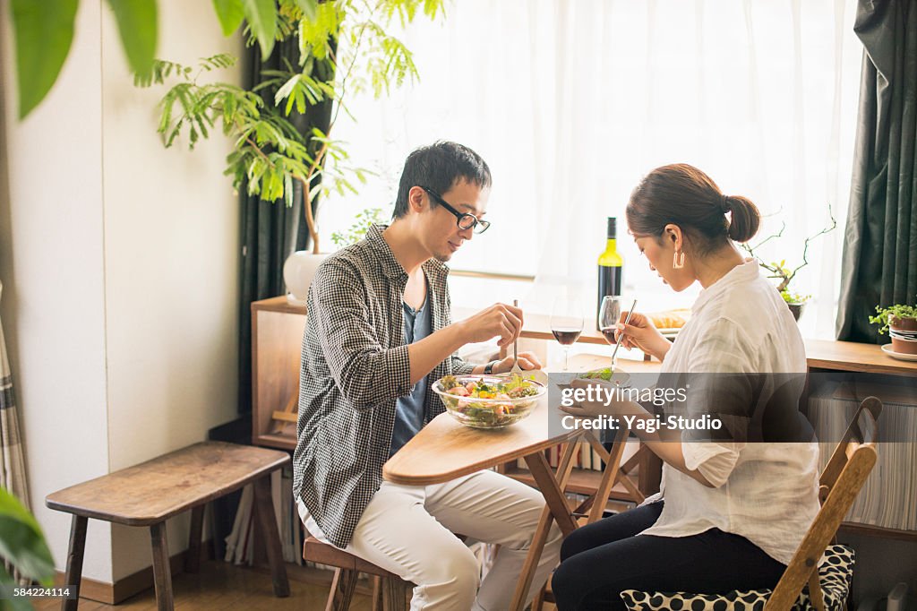 Mid adult couple eat lunch with wine