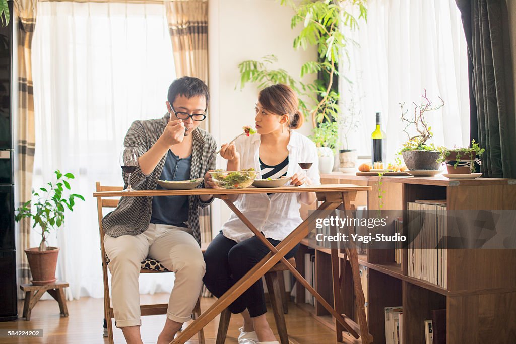 Mid adult couple eat lunch with wine
