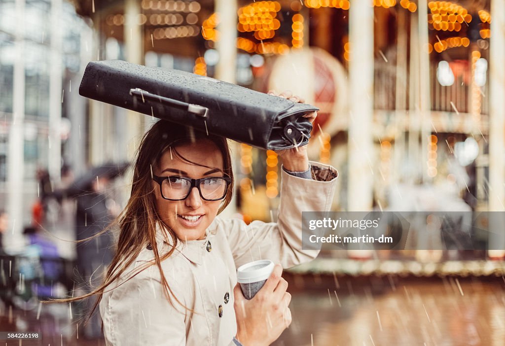 Business woman hiding from the rain