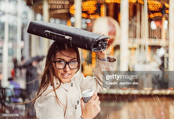 business woman hiding from the rain - covering stock pictures, royalty-free photos & images