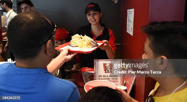 An employee handles a tray of food during the opening of a new Kentucky Fried Chicken branch on July 28, 2016 in Milan, Italy. KFC Milan seats 160...