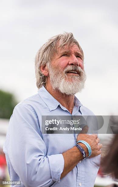 Harrison Ford places his hand over his heart during the playing of the "Star-Spangled Banner" at the EAA's AirVenture Air Show on July 28, 2016 in...