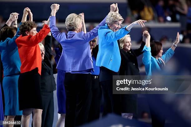 Members of the Democratic Women of the Senate raise their hands after delivering remarks on the fourth day of the Democratic National Convention at...