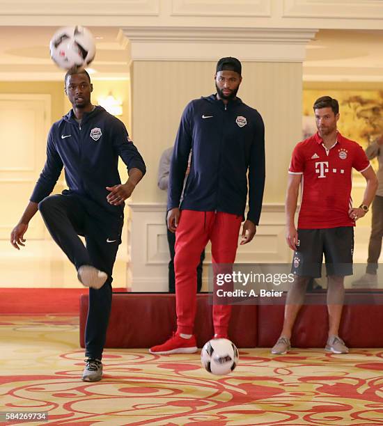 Xabi Alonso of Bayern Muenchen watches NBA players DeMarcus Cousins of Sacramento Kings and Harrison Barnes of Dallas Mavericks playing soccer in an...