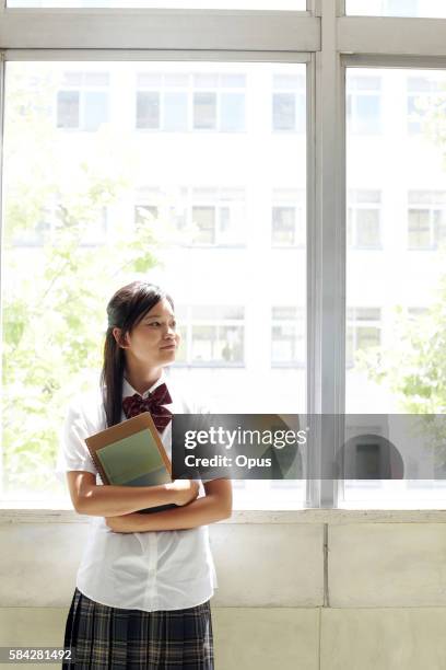 schoolgirl by window - only japanese fotografías e imágenes de stock