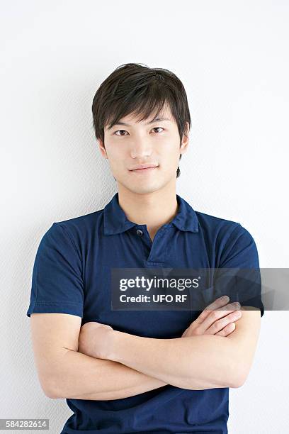 young man with crossed arms - polo shirt stock pictures, royalty-free photos & images