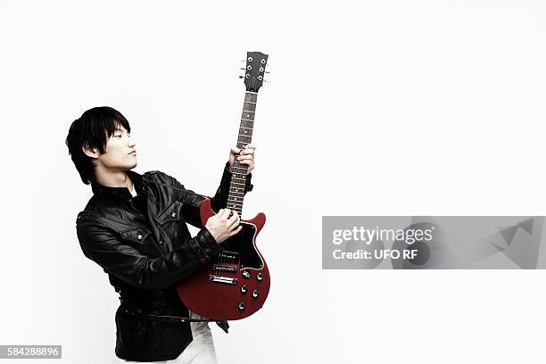 young man in leather jacket playing electric guitar - vintage electric guitar stock pictures, royalty-free photos & images