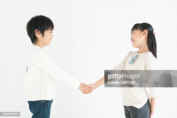 boy and girl shaking hands - asian kid studio shot side stock pictures, royalty-free photos & images