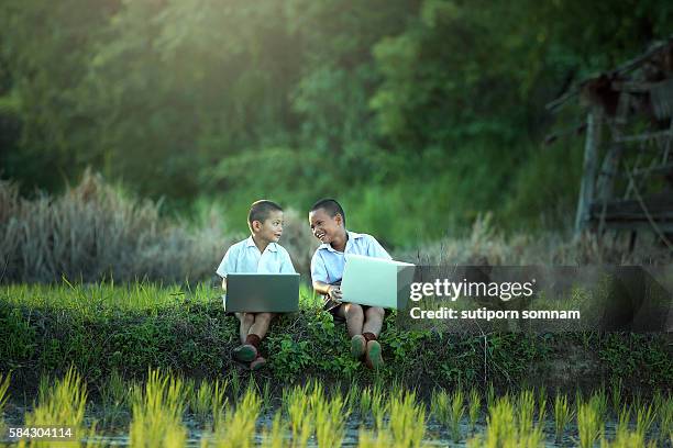 young boy playing laptop - boy thailand stock-fotos und bilder