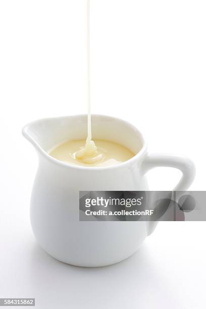 condensed milk being poured into pitcher - condensed milk foto e immagini stock