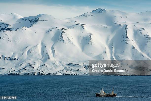 fishing boat in sea with snow capped mountains - akureyri iceland stock-fotos und bilder