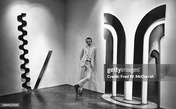 Portrait of British Pop artist Gerald Laing as he poses with his work at the Richard L Feigen Gallery, New York, New York, November 6, 1965.
