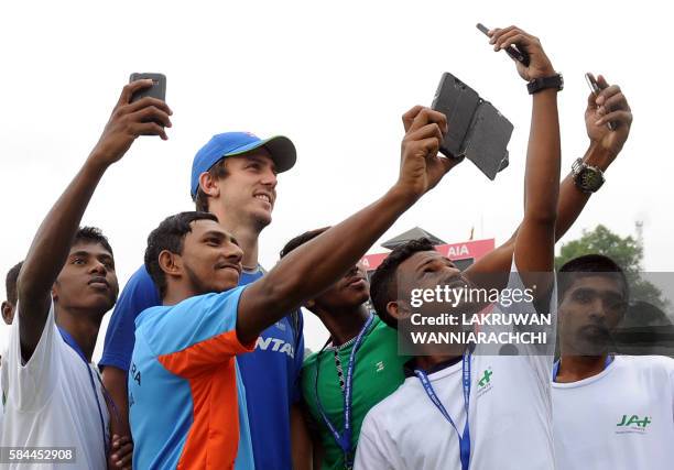 Sri Lanka's ground staff take selfies with Australia's Mitchell Marsh whilst rain and bad light delayed the start of the fourth day's play in the...