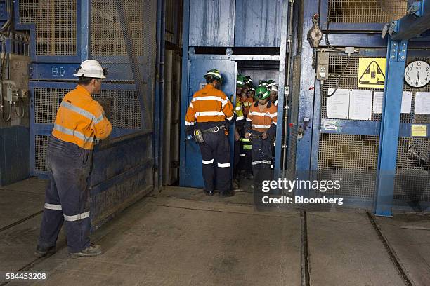 Workers exit an elevator from a deep mine shaft at the end of a shift at the Oyu Tolgoi copper-gold mine, jointly owned by Rio Tinto Group's...