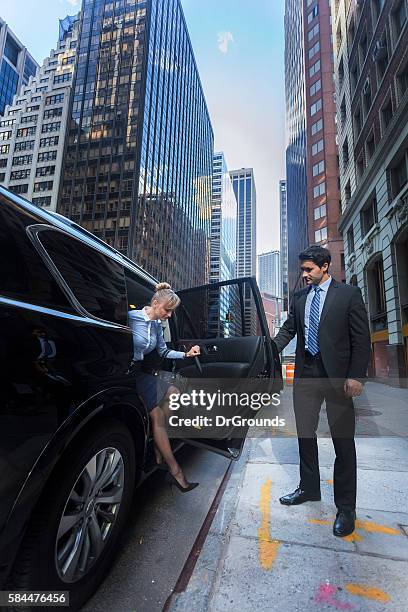 business man opening car door for woman - limo stockfoto's en -beelden