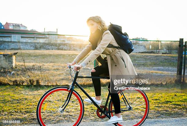 young woman enduring a long city bicycle ride - gå vidare bildbanksfoton och bilder