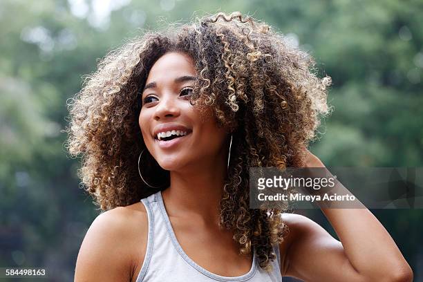 young latina woman laughing - afro hairstyle stock-fotos und bilder
