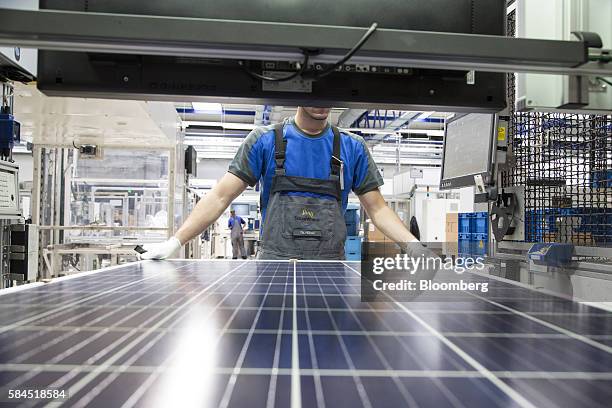 An employee carries out quality control checks on photovoltaic modules following manufacture at Solarworld AG in Freiberg, Germany, on Thursday, July...