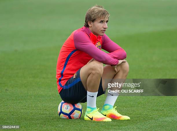 Barcelona's Spanish midfielder Sergi Samper sits on a ball during a team training session at St George's Park near Burton-on-Trent, central England,...